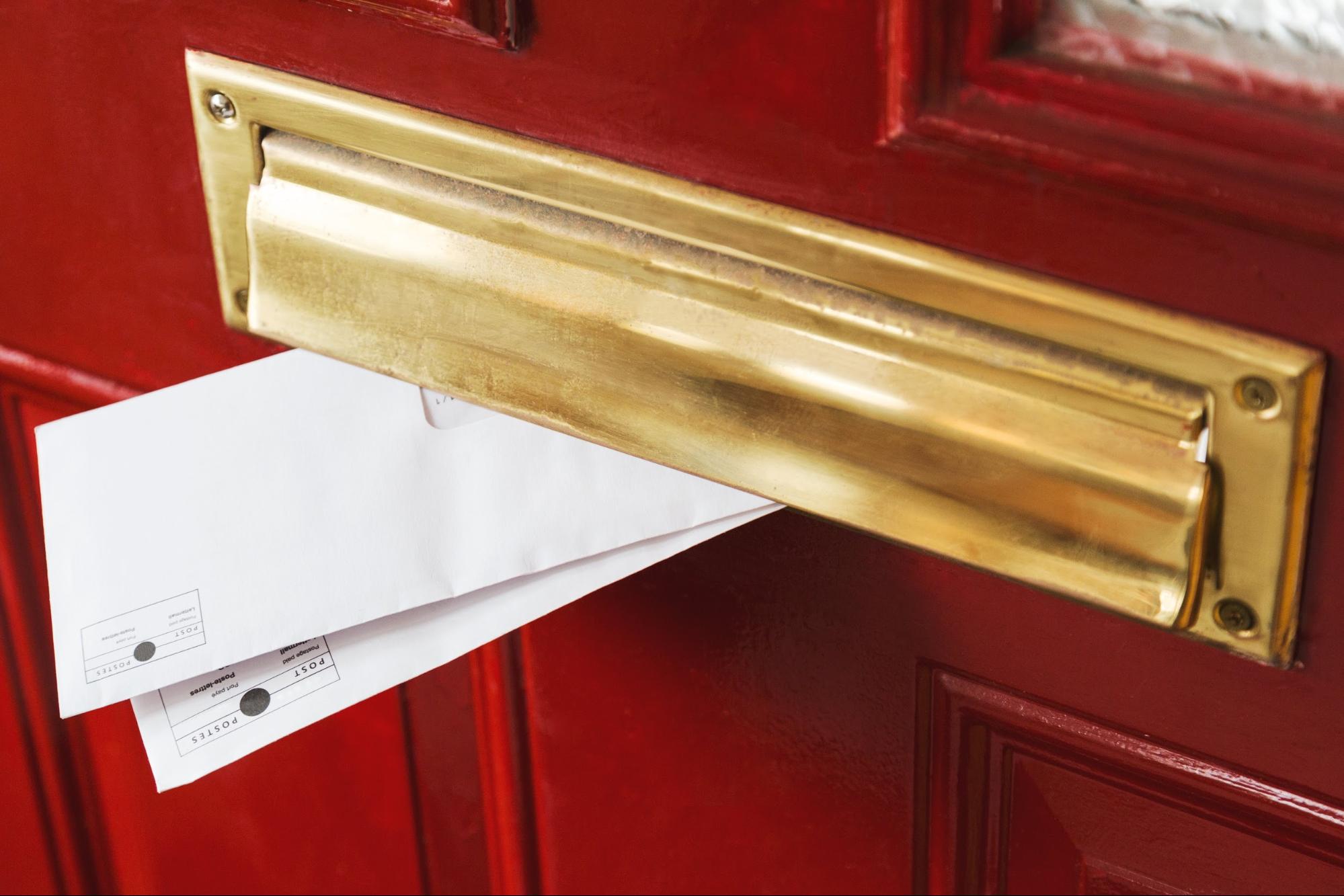 Листи у поштовому отворі двері ілюструють Email-маркетинг.